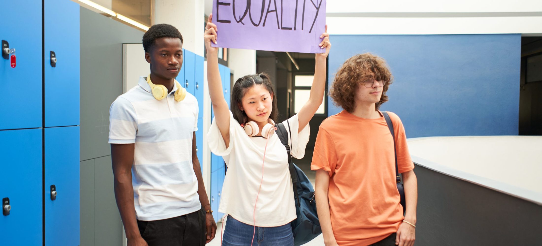 Group of students carrying a banner at school protesting for equality.